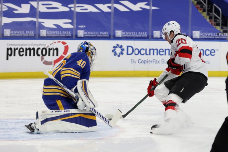 Jan 31, 2021; Buffalo, New York, USA; New Jersey Devils center Michael McLeod (20) scores a goal on Buffalo Sabres goaltender Carter Hutton (40) during the first period at KeyBank Center. Mandatory Credit: Timothy T. Ludwig-USA TODAY Sports