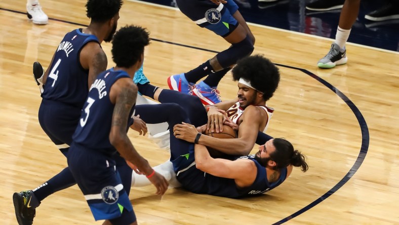 Jan 31, 2021; Minneapolis, Minnesota, USA; Cleveland Cavaliers center Jarrett Allen (middle) and Minnesota Timberwolves guard Ricky Rubio (9) battle for the ball in the second quarter at Target Center. Mandatory Credit: David Berding-USA TODAY Sports