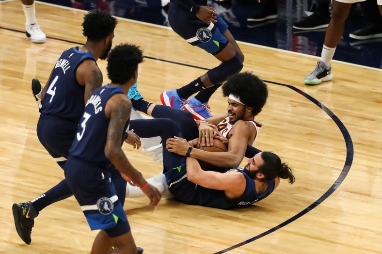 Jan 31, 2021; Minneapolis, Minnesota, USA; Cleveland Cavaliers center Jarrett Allen (middle) and Minnesota Timberwolves guard Ricky Rubio (9) battle for the ball in the second quarter at Target Center. Mandatory Credit: David Berding-USA TODAY Sports