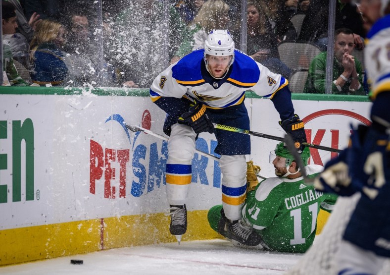 Feb 21, 2020; Dallas, Texas, USA; St. Louis Blues defenseman Carl Gunnarsson (4) and Dallas Stars center Andrew Cogliano (11) chase the puck during the second period at the American Airlines Center. Mandatory Credit: Jerome Miron-USA TODAY Sports