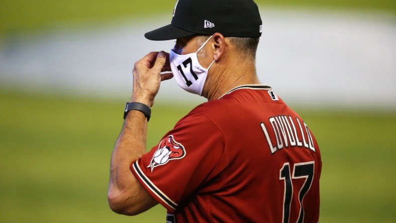 Jul 3, 2020; Phoenix, AZ, USA; Arizona Diamondbacks manager Torey Lovullo adjusts his mask during summer camp workouts at Chase Field. Major League Baseball workouts officially started on Friday after the COVID-19 coronavirus pandemic shuttered spring training in March. Mandatory Credit: Rob Schumacher/The Arizona Republic via USA TODAY NETWORK