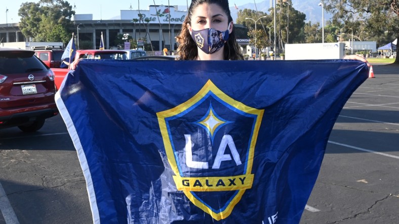 Jul 13, 2020; Pasadena, California, United States; LA Galaxy fan Chanie Franco  poses with flag at a drive-in viewing party at the Rose Bowl to watch the MLS is Back Tournament game against the Portland Timbers. Mandatory Credit: Kirby Lee-USA TODAY Sports