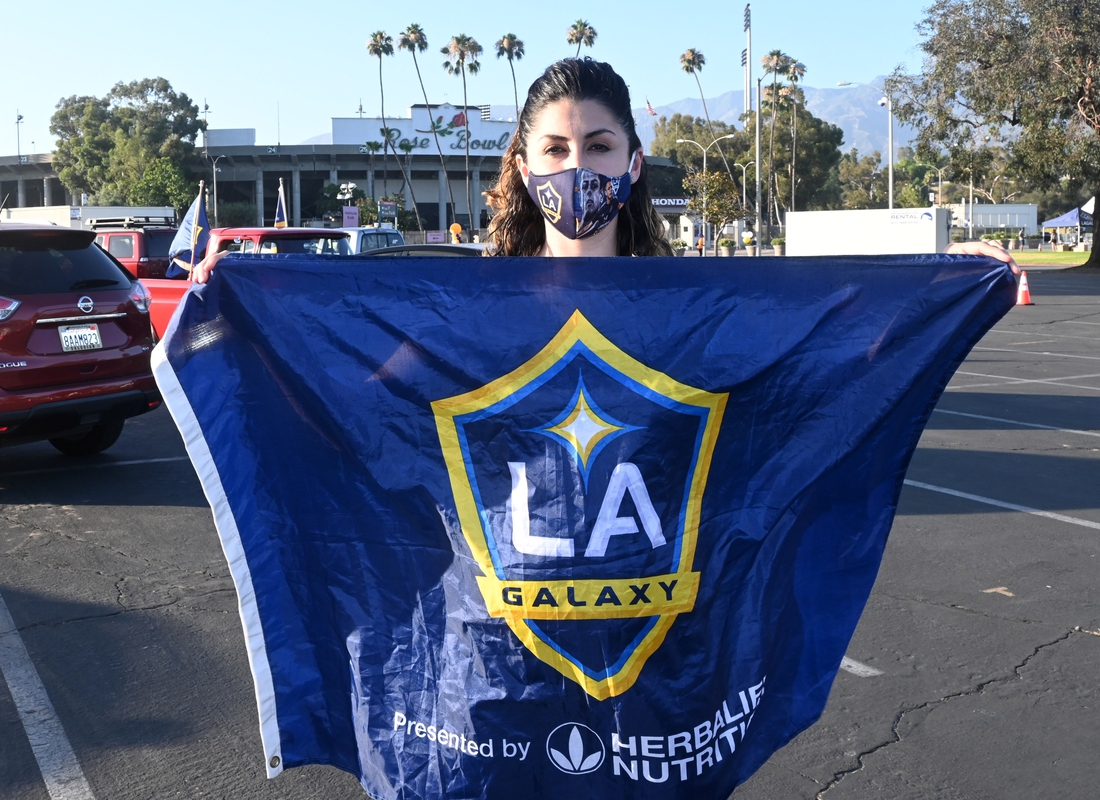 Jul 13, 2020; Pasadena, California, United States; LA Galaxy fan Chanie Franco  poses with flag at a drive-in viewing party at the Rose Bowl to watch the MLS is Back Tournament game against the Portland Timbers. Mandatory Credit: Kirby Lee-USA TODAY Sports