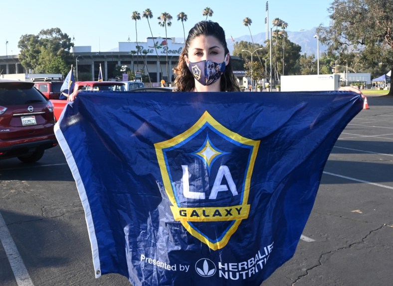 Jul 13, 2020; Pasadena, California, United States; LA Galaxy fan Chanie Franco  poses with flag at a drive-in viewing party at the Rose Bowl to watch the MLS is Back Tournament game against the Portland Timbers. Mandatory Credit: Kirby Lee-USA TODAY Sports