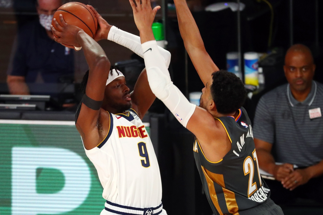 Aug 3, 2020; Lake Buena Vista, Florida, USA; Denver Nuggets forward Jerami Grant (9) handles the ball against Oklahoma City Thunder guard Andre Roberson (21) during the first quarter in a NBA basketball game at The Arena. Mandatory Credit: Kim Klement-USA TODAY Sports