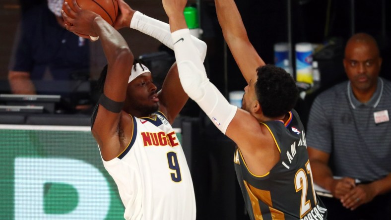 Aug 3, 2020; Lake Buena Vista, Florida, USA; Denver Nuggets forward Jerami Grant (9) handles the ball against Oklahoma City Thunder guard Andre Roberson (21) during the first quarter in a NBA basketball game at The Arena. Mandatory Credit: Kim Klement-USA TODAY Sports