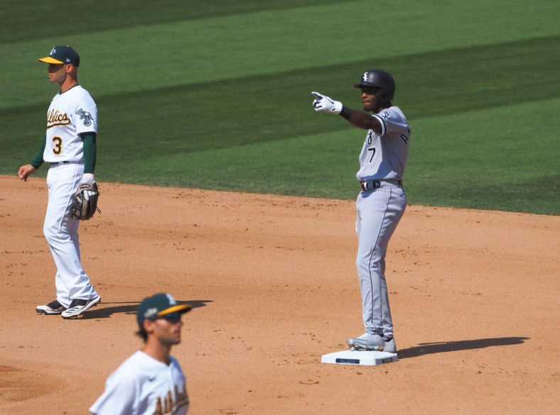 Sep 29, 2020; Oakland, California, USA; Chicago White Sox shortstop Tim Anderson (7) gestures to the White Sox dugout between Oakland Athletics second baseman Tommy La Stella (3) and first baseman Matt Olson (28) after hitting a double during the seventh inning at Oakland Coliseum. Mandatory Credit: Kelley L Cox-USA TODAY Sports