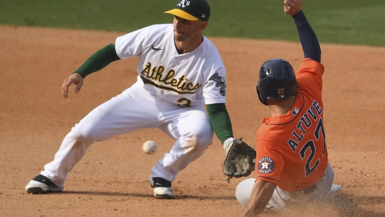 Oct 5, 2020; Los Angeles, California, USA; Oakland Athletics second baseman Tommy La Stella (3) tags out Houston Astros second baseman Jose Altuve (27) on a steal attempt during the eighth inning in game one of the 2020 ALDS at Dodger Stadium. Mandatory Credit: Jayne Kamin-Oncea-USA TODAY Sports