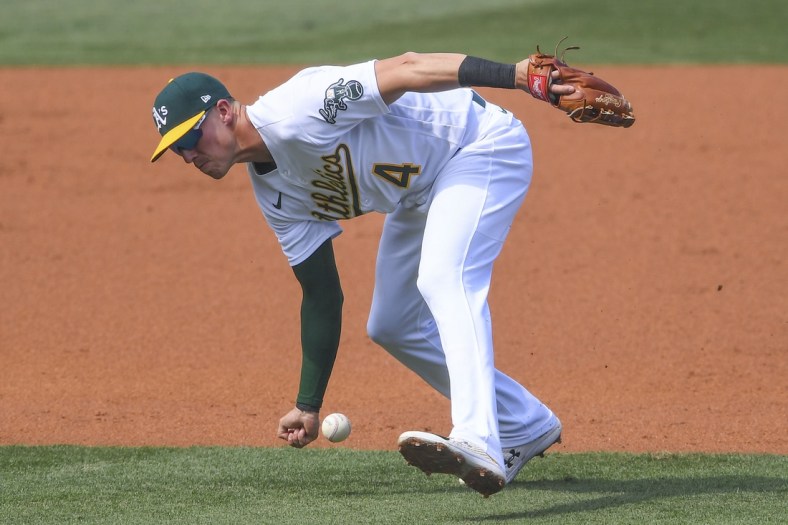 Oct 5, 2020; Los Angeles, California, USA; Oakland Athletics third baseman Jake Lamb (4) misses the baseball on a single by Houston Astros second baseman Yuli Gurriel (not pictured) during the second inning in game one of the 2020 ALDS at Dodger Stadium. Mandatory Credit: Jayne Kamin-Oncea-USA TODAY Sports