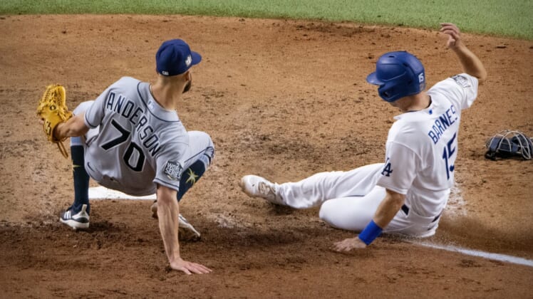 Oct 27, 2020; Arlington, Texas, USA; Los Angeles Dodgers catcher Austin Barnes (15) slides past Tampa Bay Rays relief pitcher Nick Anderson (70) during the sixth inning in game six of the 2020 World Series at Globe Life Field. Mandatory Credit: Jerome Miron-USA TODAY Sports