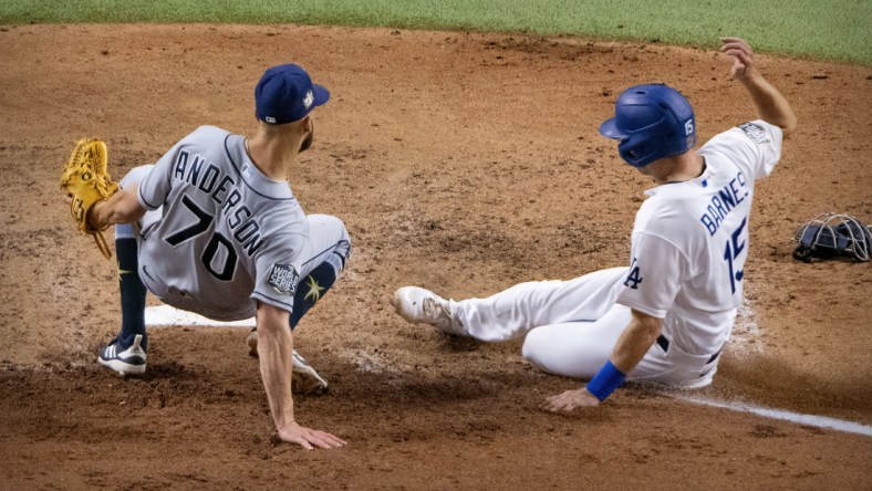 Oct 27, 2020; Arlington, Texas, USA; Los Angeles Dodgers catcher Austin Barnes (15) slides past Tampa Bay Rays relief pitcher Nick Anderson (70) during the sixth inning in game six of the 2020 World Series at Globe Life Field. Mandatory Credit: Jerome Miron-USA TODAY Sports