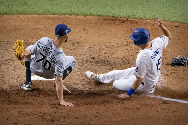 Oct 27, 2020; Arlington, Texas, USA; Los Angeles Dodgers catcher Austin Barnes (15) slides past Tampa Bay Rays relief pitcher Nick Anderson (70) during the sixth inning in game six of the 2020 World Series at Globe Life Field. Mandatory Credit: Jerome Miron-USA TODAY Sports