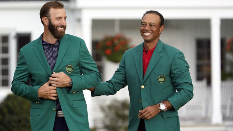 Nov 15, 2020; Augusta, Georgia, USA; 2019 Masters champion Tiger Woods presents Dustin Johnson with the green jacket after winning The Masters golf tournament at Augusta National GC. Mandatory Credit: Michael Madrid-USA TODAY Sports