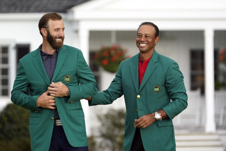 Nov 15, 2020; Augusta, Georgia, USA; 2019 Masters champion Tiger Woods presents Dustin Johnson with the green jacket after winning The Masters golf tournament at Augusta National GC. Mandatory Credit: Michael Madrid-USA TODAY Sports