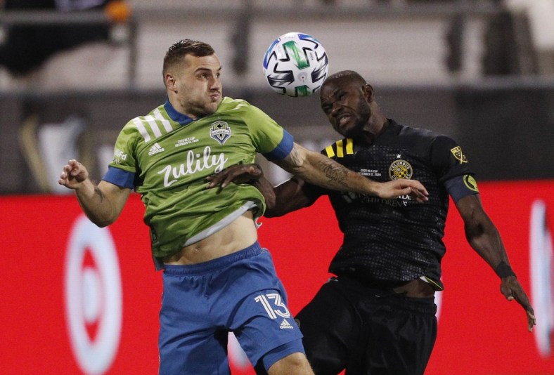 Dec 12, 2020; Columbus, Ohio, USA; Seattle Sounders forward Jordan Morris (13) goes up for a header against Columbus Crew defender Jonathan Mensah (4) in the first half during the 2020 MLS Cup Final at MAPFRE Stadium. Mandatory Credit: Trevor Ruszkowski-USA TODAY Sports