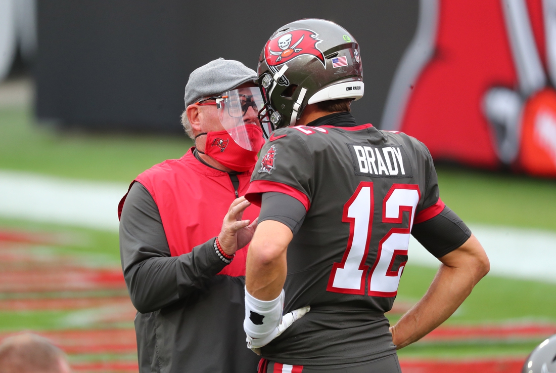 Jan 3, 2021; Tampa, Florida, USA; Tampa Bay Buccaneers head coach Bruce Arians (L) and quarterback Tom Brady (12) talk prior to the game against the Atlanta Falcons at Raymond James Stadium. Mandatory Credit: Kim Klement-USA TODAY Sports