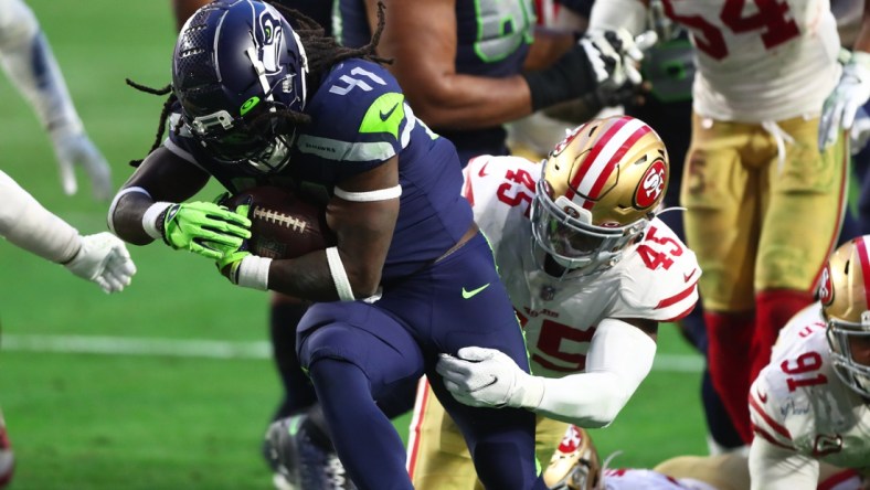 Jan 3, 2021; Glendale, Arizona, USA; Seattle Seahawks running back Alex Collins (41) is tackled by San Francisco 49ers linebacker Demetrius Flannigan-Fowles (45) at State Farm Stadium. Mandatory Credit: Mark J. Rebilas-USA TODAY Sports