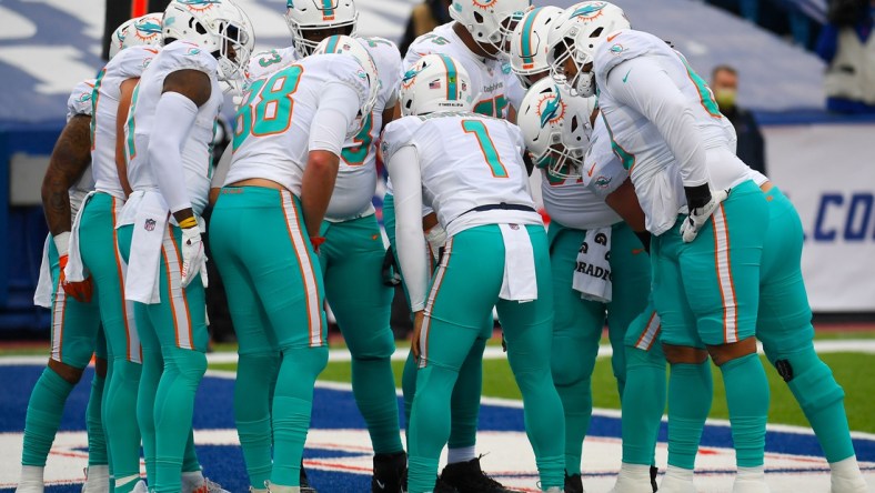 Jan 3, 2021; Orchard Park, New York, USA; Miami Dolphins quarterback Tua Tagovailoa (1) calls a play in the huddle against the Buffalo Bills during the first quarter at Bills Stadium. Mandatory Credit: Rich Barnes-USA TODAY Sports