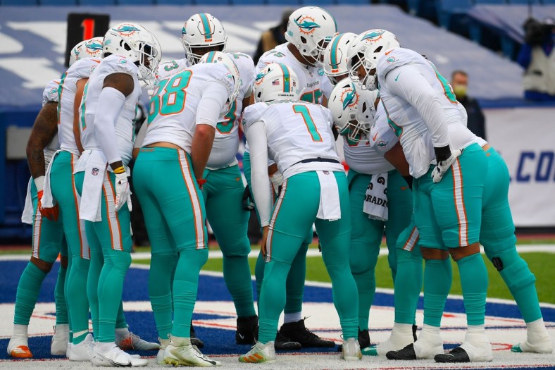 Jan 3, 2021; Orchard Park, New York, USA; Miami Dolphins quarterback Tua Tagovailoa (1) calls a play in the huddle against the Buffalo Bills during the first quarter at Bills Stadium. Mandatory Credit: Rich Barnes-USA TODAY Sports