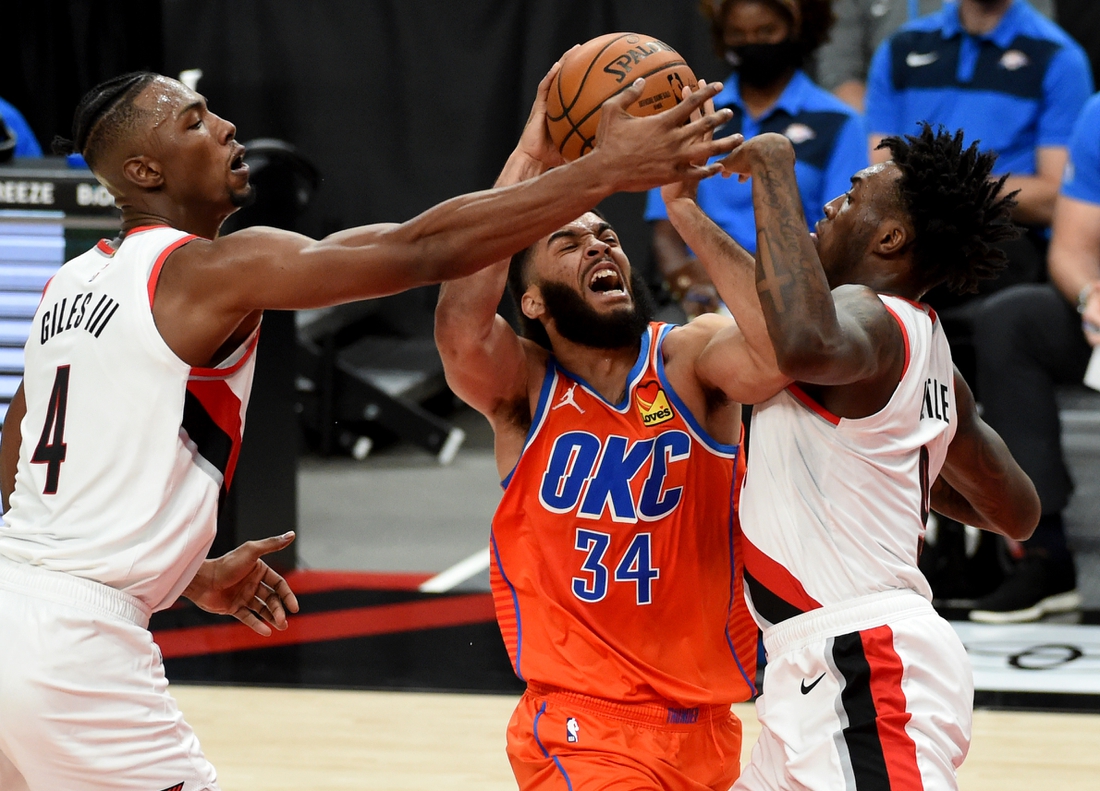 Jan 25, 2021; Portland, Oregon, USA; Oklahoma City Thunder guard Kenrich Williams (34) derives to the basket on Portland Trail Blazers forward Harry Giles III (4) and forward Nassir Little (9) during the first half at Moda Center. Mandatory Credit: Steve Dykes-USA TODAY Sports