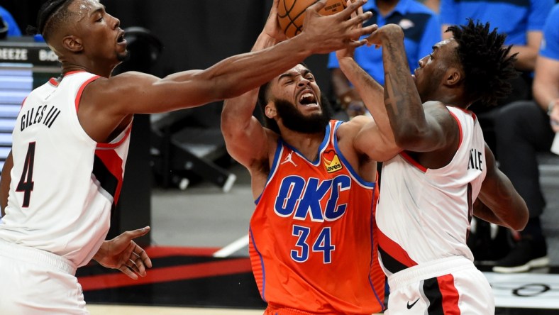 Jan 25, 2021; Portland, Oregon, USA; Oklahoma City Thunder guard Kenrich Williams (34) derives to the basket on Portland Trail Blazers forward Harry Giles III (4) and forward Nassir Little (9) during the first half at Moda Center. Mandatory Credit: Steve Dykes-USA TODAY Sports