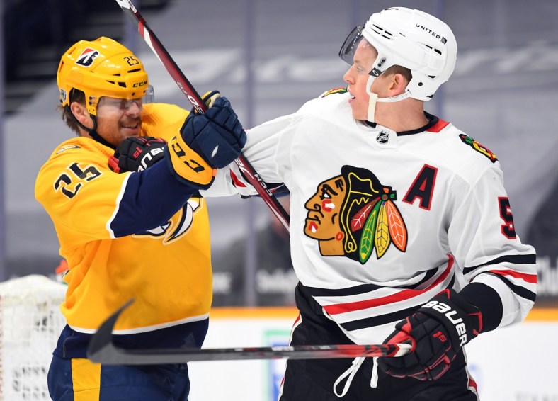 Jan 26, 2021; Nashville, Tennessee, USA; Nashville Predators right wing Mathieu Olivier (25) and Chicago Blackhawks defenseman Connor Murphy (5) exchange shoves after the whistle during the first period at Bridgestone Arena. Mandatory Credit: Christopher Hanewinckel-USA TODAY Sports