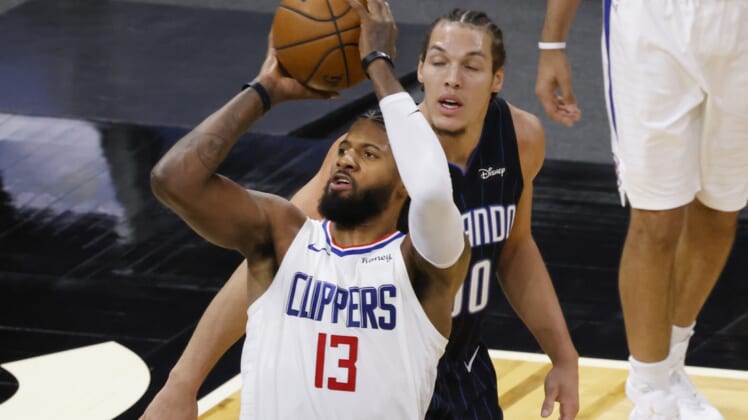 Jan 29, 2021; Orlando, Florida, USA;  LA Clippers guard Paul George (13) shoots the ball in front of Orlando Magic forward Aaron Gordon (00) during the third quarter at Amway Center. Mandatory Credit: Reinhold Matay-USA TODAY Sports