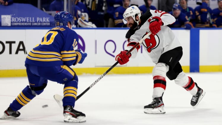 Jan 30, 2021; Buffalo, New York, USA;  Buffalo Sabres defenseman Henri Jokiharju (10) tries to block a shot on goal by New Jersey Devils right wing Kyle Palmieri (21) during the third period at KeyBank Center. Mandatory Credit: Timothy T. Ludwig-USA TODAY Sports