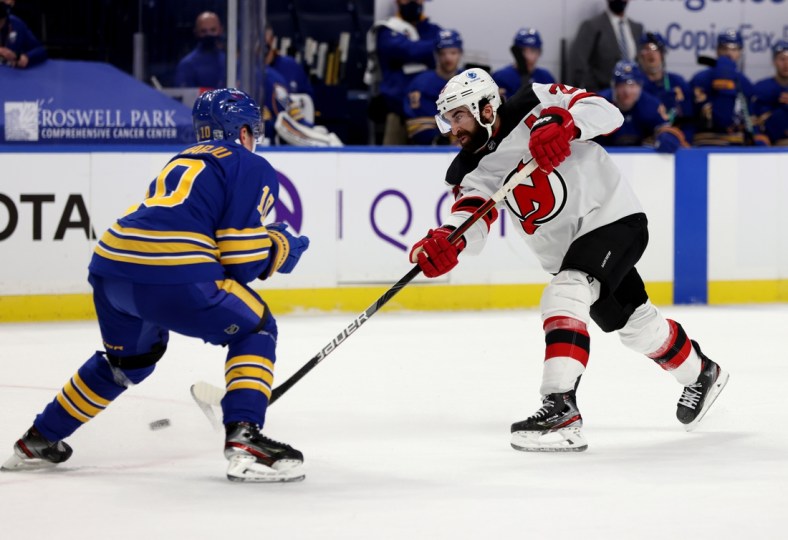 Jan 30, 2021; Buffalo, New York, USA;  Buffalo Sabres defenseman Henri Jokiharju (10) tries to block a shot on goal by New Jersey Devils right wing Kyle Palmieri (21) during the third period at KeyBank Center. Mandatory Credit: Timothy T. Ludwig-USA TODAY Sports