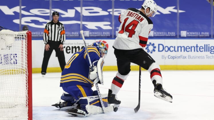 Jan 31, 2021; Buffalo, New York, USA; New Jersey Devils right wing Nathan Bastian (14) deflects a shot on Buffalo Sabres goaltender Carter Hutton (40) during the third period at KeyBank Center. Mandatory Credit: Timothy T. Ludwig-USA TODAY Sports