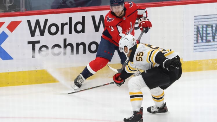 Feb 1, 2021; Washington, District of Columbia, USA; Washington Capitals defenseman Nick Jensen (3) passes the puck as Boston Bruins defenseman Jeremy Lauzon (55) defends in the first period at Capital One Arena. Mandatory Credit: Geoff Burke-USA TODAY Sports