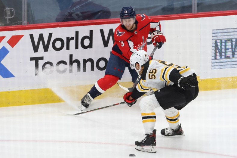 Feb 1, 2021; Washington, District of Columbia, USA; Washington Capitals defenseman Nick Jensen (3) passes the puck as Boston Bruins defenseman Jeremy Lauzon (55) defends in the first period at Capital One Arena. Mandatory Credit: Geoff Burke-USA TODAY Sports