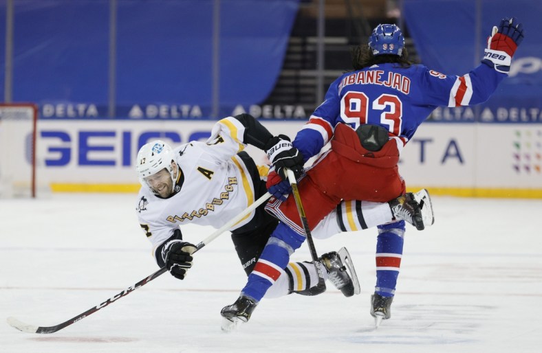 Feb 1, 2021; New York, New York, USA; Bryan Rust #17 of the Pittsburgh Penguins trips over Mika Zibanejad #93 of the New York Rangers during the third period at Madison Square Garden on February 01, 2021 in New York City. The Rangers won 3-1. Mandatory Credit:  Sarah Stier/POOL PHOTOS-USA TODAY Sports
