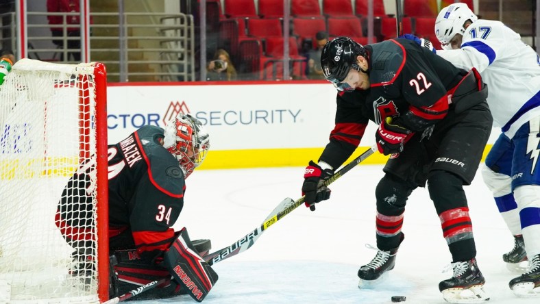 Jan 28, 2021; Raleigh, North Carolina, USA;  Carolina Hurricanes goaltender Petr Mrazek (34) and defenseman Brett Pesce (22) watch the puck against the Tampa Bay Lightning at PNC Arena. Mandatory Credit: James Guillory-USA TODAY Sports