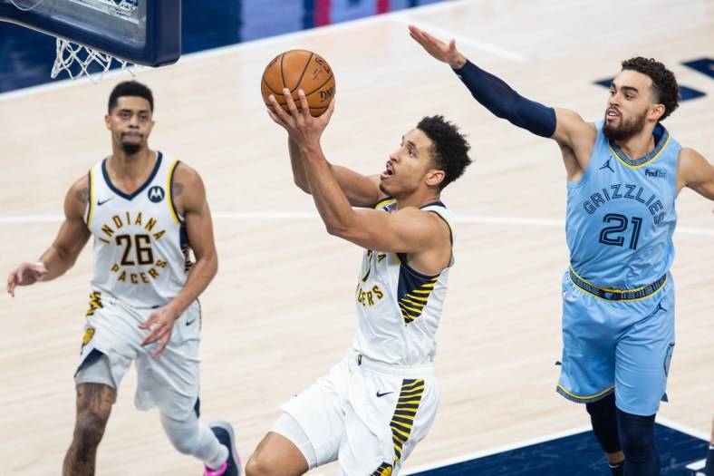 Feb 2, 2021; Indianapolis, Indiana, USA; Indiana Pacers guard Malcolm Brogdon (7) shoots the ball wheel Memphis Grizzlies guard Tyus Jones (21) defends in the third quarter at Bankers Life Fieldhouse. Mandatory Credit: Trevor Ruszkowski-USA TODAY Sports