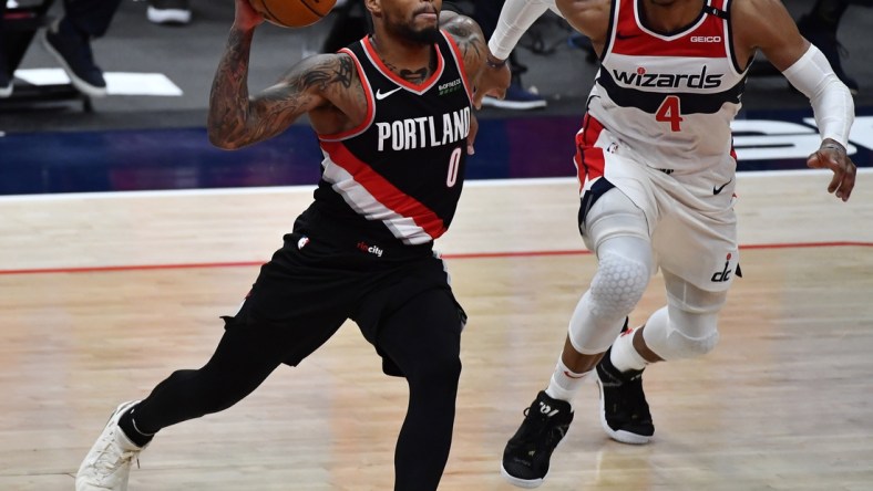 Feb 2, 2021; Washington, District of Columbia, USA; Portland Trail Blazers guard Damian Lillard (0) drives as Washington Wizards guard Russell Westbrook (4) chases during the fourth quarter at Capital One Arena. Mandatory Credit: Brad Mills-USA TODAY Sports