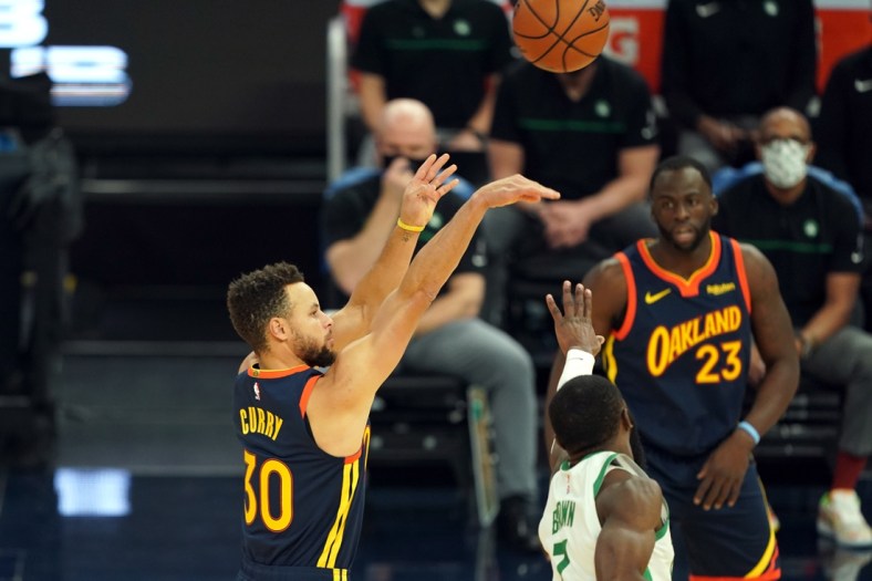 Feb 2, 2021; San Francisco, California, USA; Golden State Warriors guard Stephen Curry (30) hits a 3 pointer over Boston Celtics guard Jaylen Brown (7) during the first quarter at Chase Center. Mandatory Credit: Darren Yamashita-USA TODAY Sports