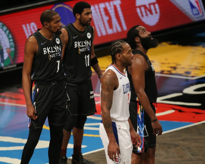 Feb 2, 2021; Brooklyn, New York, USA; Brooklyn Nets power forward Kevin Durant (7) and point guard Kyrie Irving (11) and shooting guard James Harden (13) and Los Angeles Clippers small forward Kawhi Leonard (2) await a replay review during the fourth quarter at Barclays Center. Mandatory Credit: Brad Penner-USA TODAY Sports