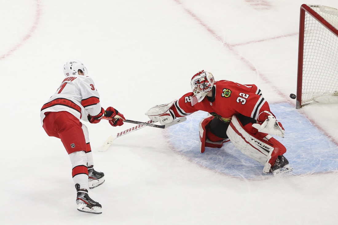 Feb 2, 2021; Chicago, Illinois, USA; Carolina Hurricanes right wing Andrei Svechnikov (37) scores a goal against Chicago Blackhawks goaltender Kevin Lankinen (32) during a shoot-out at United Center. Mandatory Credit: Kamil Krzaczynski-USA TODAY Sports