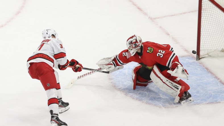 Feb 2, 2021; Chicago, Illinois, USA; Carolina Hurricanes right wing Andrei Svechnikov (37) scores a goal against Chicago Blackhawks goaltender Kevin Lankinen (32) during a shoot-out at United Center. Mandatory Credit: Kamil Krzaczynski-USA TODAY Sports