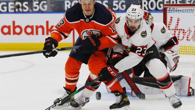 Feb 2, 2021; Edmonton, Alberta, CAN; Edmonton Oilers forward Jesse Puljujarvi (13) and Ottawa Senators forward Cedric Paquette (23) look for a loose puck during the first period at Rogers Place. Mandatory Credit: Perry Nelson-USA TODAY Sports