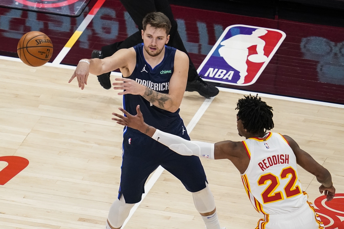 Feb 3, 2021; Atlanta, Georgia, USA; Dallas Mavericks guard Luka Doncic (77) passes in front of Atlanta Hawks guard Cam Reddish (22) during the first quarter at State Farm Arena. Mandatory Credit: Dale Zanine-USA TODAY Sports