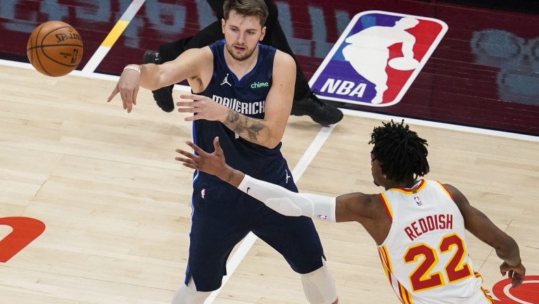 Feb 3, 2021; Atlanta, Georgia, USA; Dallas Mavericks guard Luka Doncic (77) passes in front of Atlanta Hawks guard Cam Reddish (22) during the first quarter at State Farm Arena. Mandatory Credit: Dale Zanine-USA TODAY Sports