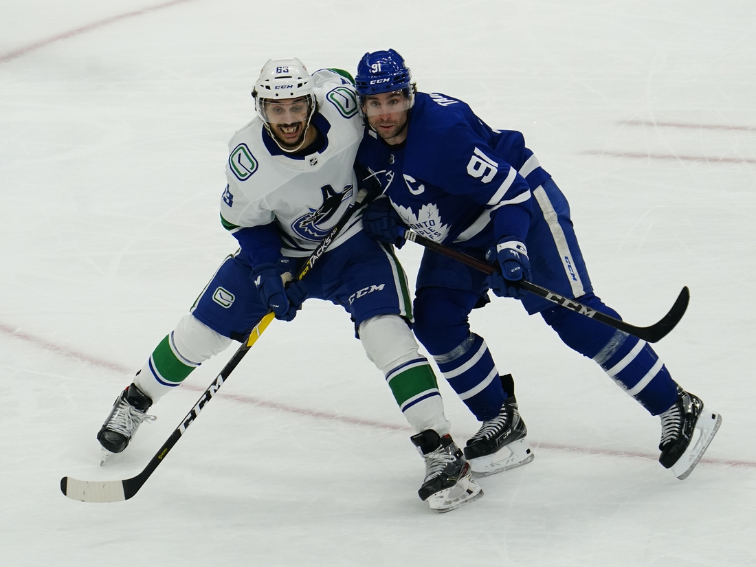 Feb 4, 2021; Toronto, Ontario, CAN; Vancouver Canucks defenseman Jalen Chatfield (63) and Toronto Maple Leafs forward John Tavares (91) battle for position during the third period at Scotiabank Arena. Toronto defeated Vancouver. Mandatory Credit: John E. Sokolowski-USA TODAY Sports