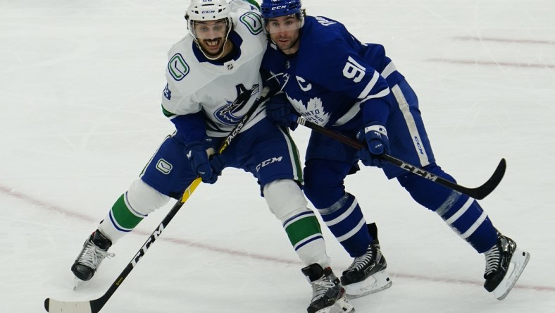 Feb 4, 2021; Toronto, Ontario, CAN; Vancouver Canucks defenseman Jalen Chatfield (63) and Toronto Maple Leafs forward John Tavares (91) battle for position during the third period at Scotiabank Arena. Toronto defeated Vancouver. Mandatory Credit: John E. Sokolowski-USA TODAY Sports