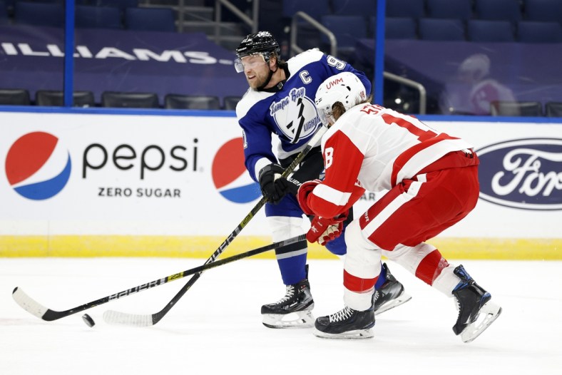 Feb 5, 2021; Tampa, Florida, USA; Tampa Bay Lightning center Steven Stamkos (91) shoots as Detroit Red Wings defenseman Marc Staal (18) defends  during the first period at Amalie Arena. Mandatory Credit: Kim Klement-USA TODAY Sports