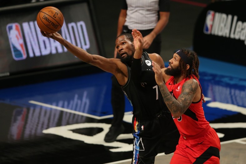Feb 5, 2021; Brooklyn, New York, USA; Brooklyn Nets power forward Kevin Durant (7) tries to keep a ball in bounds against Toronto Raptors small forward DeAndre' Bembry (95) during the first quarter at Barclays Center. Mandatory Credit: Brad Penner-USA TODAY Sports
