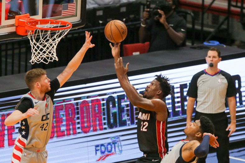 Feb 5, 2021; Miami, Florida, USA; Miami Heat forward Jimmy Butler (22) shoot a layup over Washington Wizards forward Davis Bertans (42) during the first quarter of the game at American Airlines Arena. Mandatory Credit: Sam Navarro-USA TODAY Sports