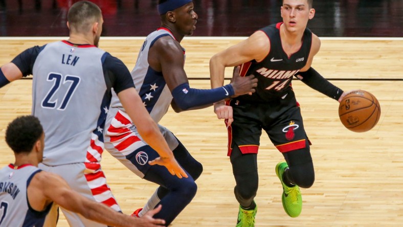 Feb 5, 2021; Miami, Florida, USA; Miami Heat guard Tyler Herro (14) dribbles the basketball around Washington Wizards forward Isaac Bonga (17) during the third quarter of the game at American Airlines Arena. Mandatory Credit: Sam Navarro-USA TODAY Sports