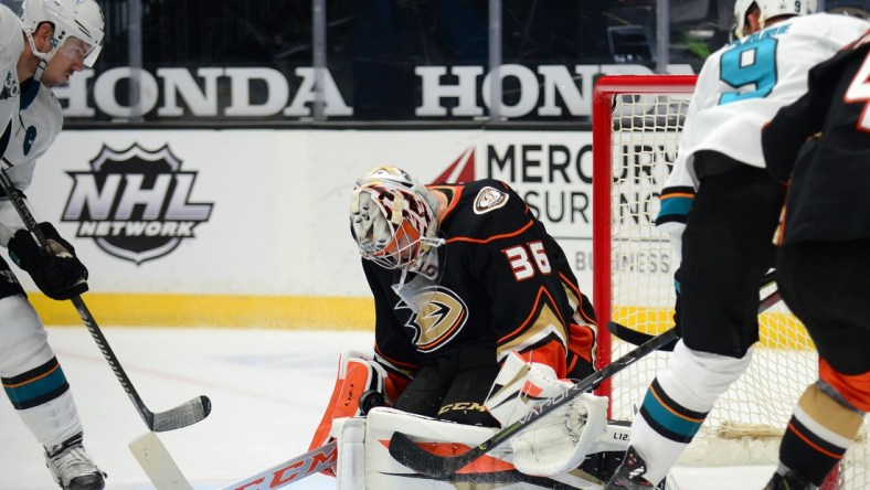 Feb 5, 2021; Anaheim, California, USA; Anaheim Ducks goaltender John Gibson (36) blocks a shot against San Jose Sharks left wing Evander Kane (9) as center Logan Couture (39) moves in for the rebound during the overtime period at Honda Center. Mandatory Credit: Gary A. Vasquez-USA TODAY Sports